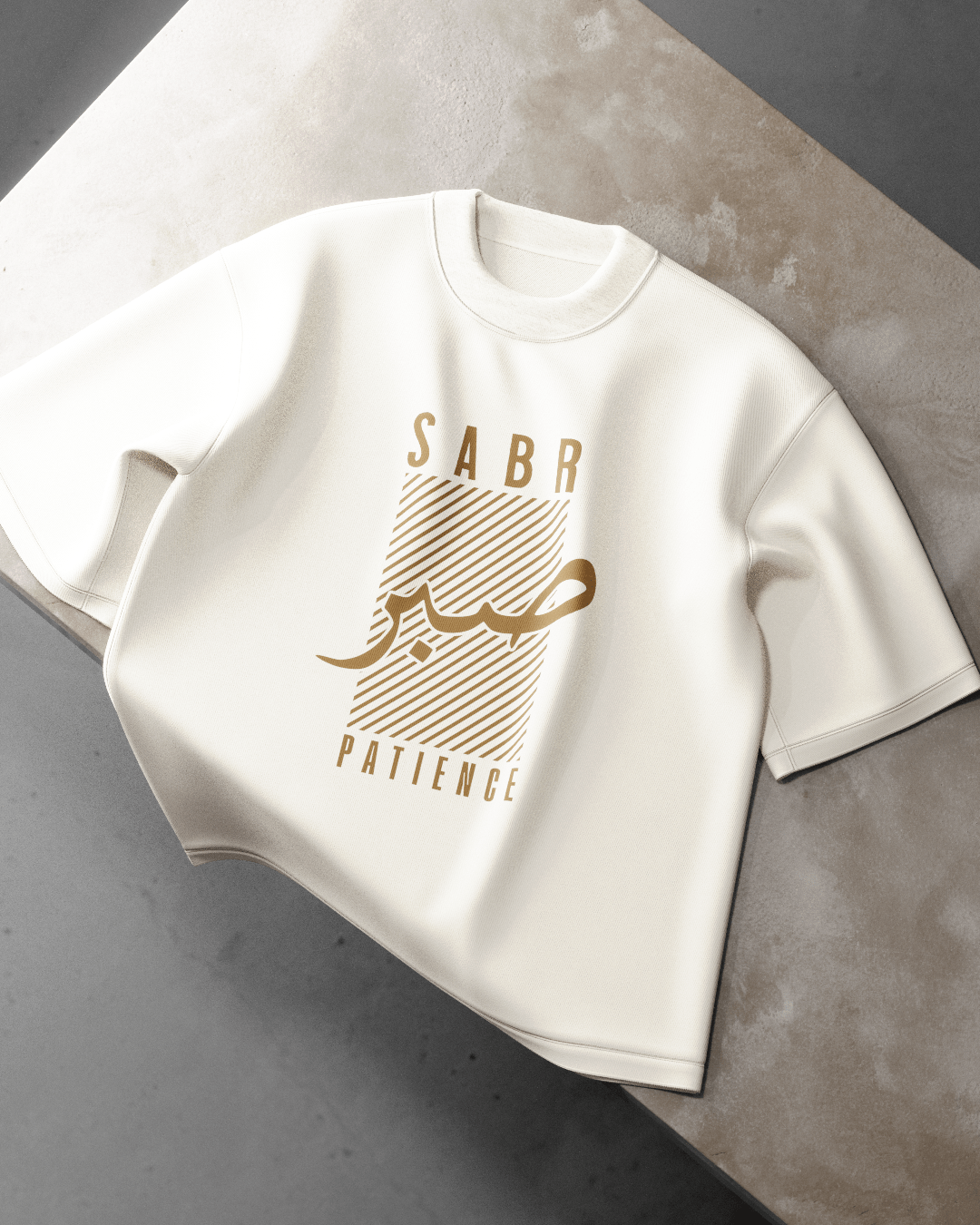 White t-shirt with gold text on a gray surface