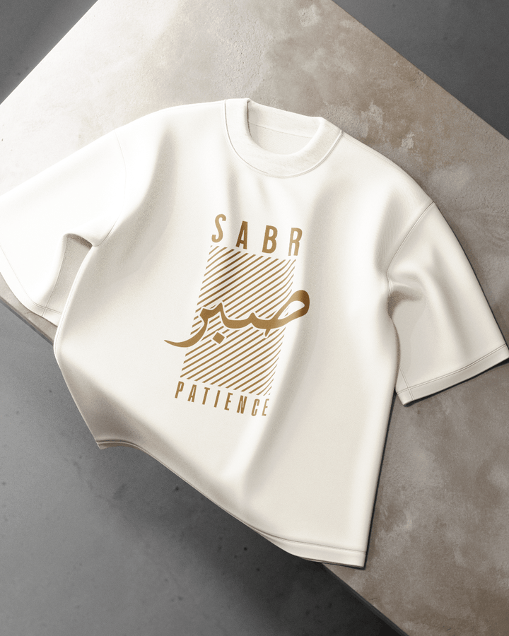 White t-shirt with gold text on a gray surface