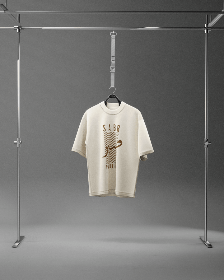 White t-shirt with gold text on a hanger against a gray background