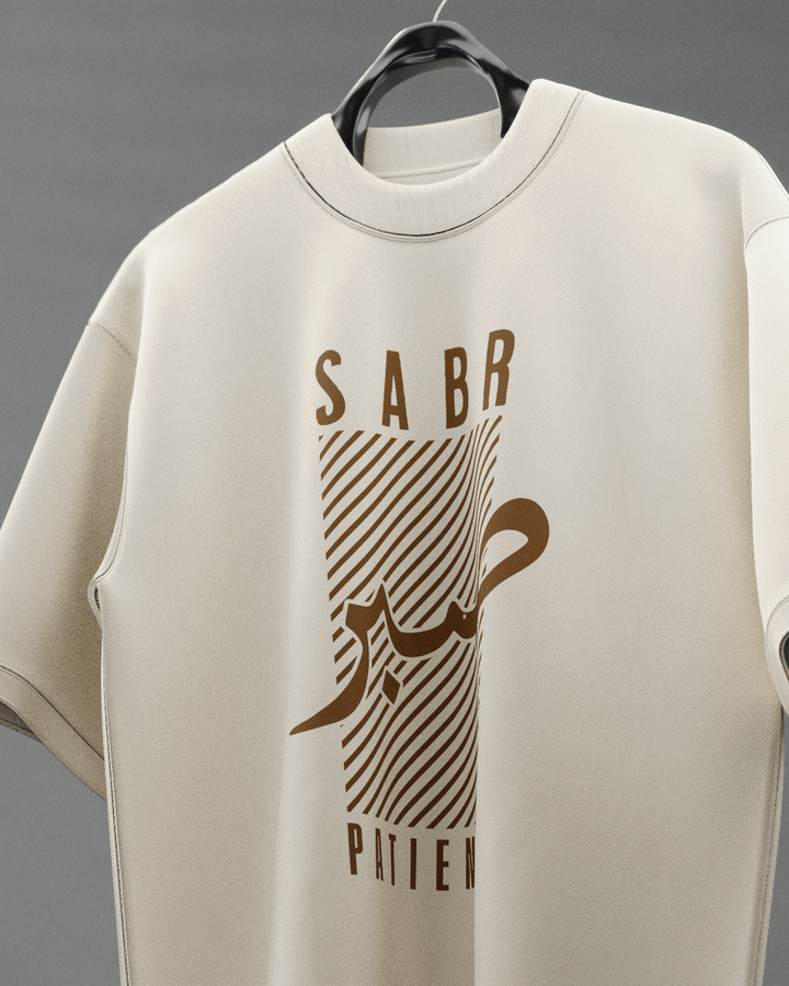 Beige sweatshirt with brown graphic design and text on a hanger against a gray background