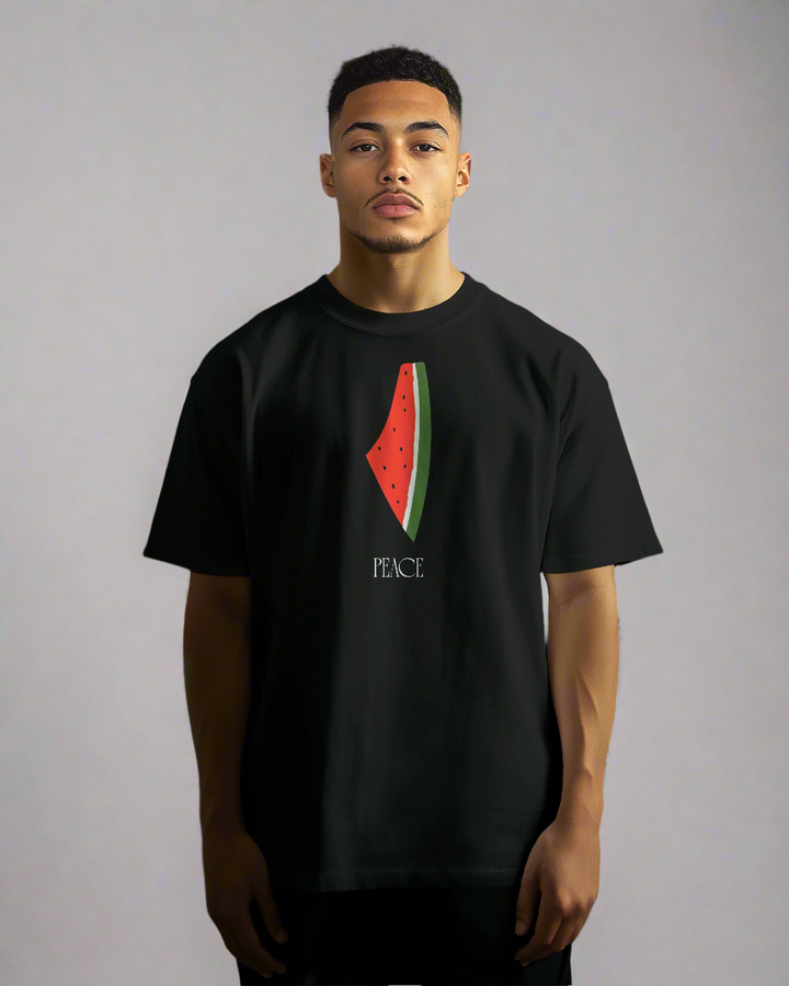 Person wearing a black t-shirt with a watermelon design and 'PEACE' text against a blurred background.