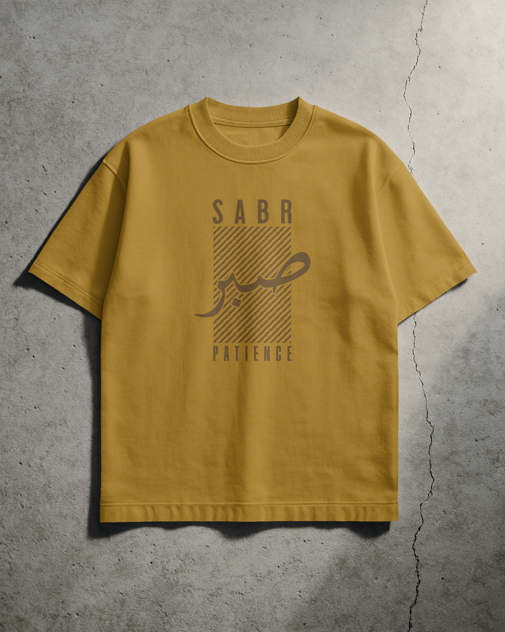 Yellow t-shirt with 'SABR Patience' text on a concrete floor background