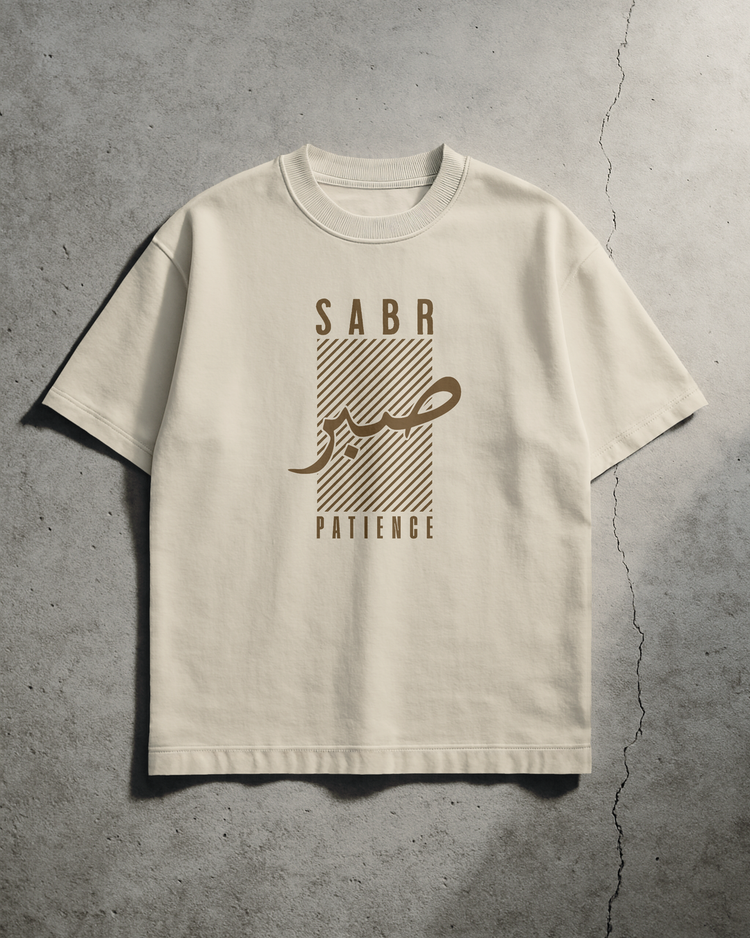 Beige t-shirt with 'SABA' and 'PATIENCE' text on a concrete surface