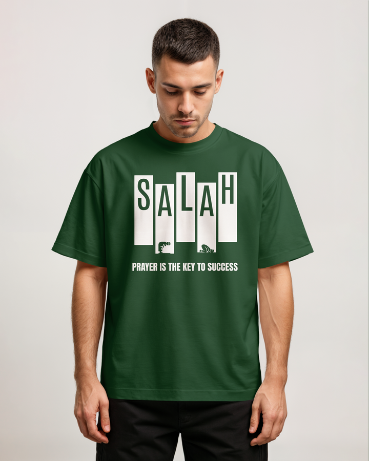 Man wearing a green t-shirt with 'SALAH' and motivational text on a plain background